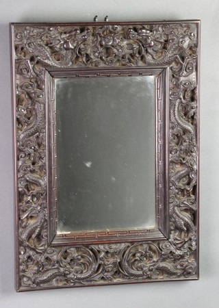 A rectangular plate mirror contained in a Chinese heavily carved hardwood frame 19" x 13 1/2" 
