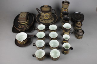 A 1970's Denby tea, coffee and dinner service with brown ground and geometric decoration comprising a teapot, 8 tea cups, 7 saucers, 3 jugs, a sauceboat and stand, 2 mugs, a butter dish and cover, a lidded jug, 2 preserve pots, a rounded rectangular dish, 3 oval dishes, 3 dinner plates and a small dish   