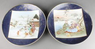 A pair of early 20th Century Satsuma plates, the blue ground with panels of figures in landscapes 13" 