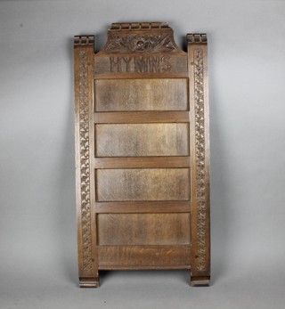 A carved oak hymn board 