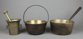 A brass preserving pan with iron handle 7 1/2", a brass saucepan with iron handle 8", a brass mortar and pestle