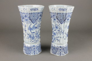 A pair of 19th Century fluted Delft vases with waisted bodies decorated with birds amongst trees beneath a band of scroll decoration 10" 
