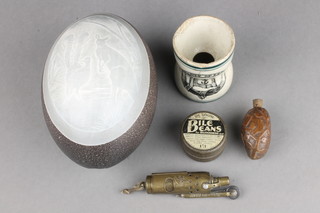 A carved ostrich egg 5", a brass Trench lighter marked JMCO Patenta, a carved scent bottle formed from a nut 2", a waisted ceramic egg cup