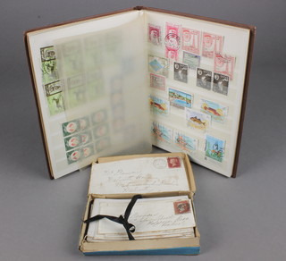 A small brown stock book of various used world stamps and 29 Victorian stamped and franked envelopes with penny reds