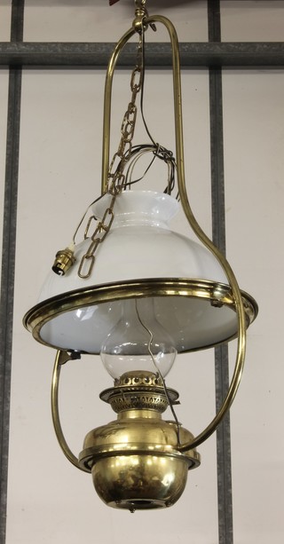 A brass hanging oil lamp with opaque glass shade, converted to electricity 