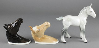 A Beswick figure of a standing dappled grey foal 7", a ditto Palomino wall mask 1384 5 1/2" and an Arab horse wall mask 1385 4" 