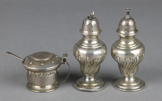 A pair of silver pepperettes of baluster form and a silver mustard pot with blue glass liner 132 grams
