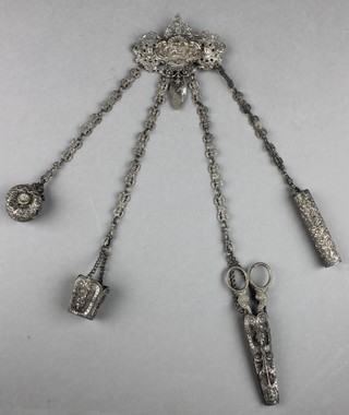 A 19th Century Continental repousse silver plated chatelaine with scroll decoration supporting a tape, needle case, needle holder and scissors