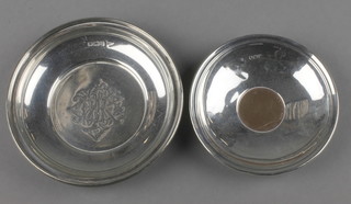 A George V circular silver nut dish with chased monogram, Sheffield 1913 and a coin set silver dish