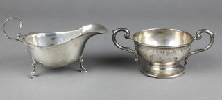 An Edwardian silver 2 handled trophy cup Birmingham 1905 and a silver sauce boat with S scroll handle, London 1937 146 grams