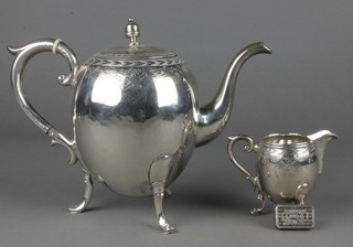 An 800 standard ovoid teapot and cream jug with chased decoration on scroll feet, a 31.1 gram silver ingot 