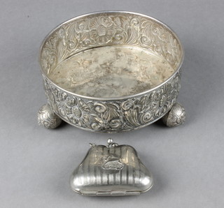 A 19th Century Continental repousse silver shallow bowl decorated with stylised flowers on ball feet, a Wembley Great Exhibition repousse purse 