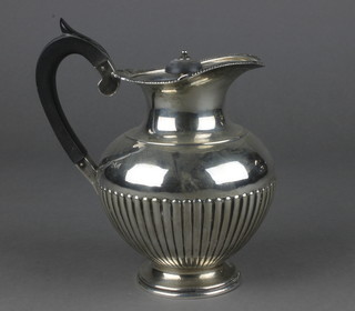 A Victorian repousse silver bulbous jug with ebony mounts, London 1894, 406 grams