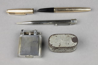 A Dunhill silver plated engine turned silver cigarette lighter, a fountain pen, pencil and nutmeg grater 
