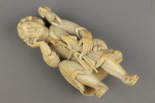 An 18th Century Continental ivory carving of a seated shepherd with 2 sheep holding a staff and wearing a pilgrim's flask about his waist 7" 