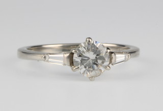 An 18ct white gold single stone diamond ring, approx. 0.8ct, the shoulders with tapered baguette diamonds size L 1/2 