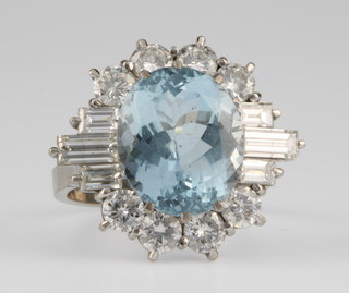An 18ct gold aquamarine and diamond dress ring, the centre stone surrounded by 14 diamonds, size O 1/2