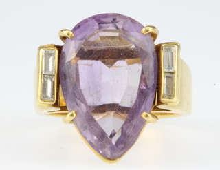 An 18ct gold amethyst and diamond ring, the pear shaped amethyst with chipped end flanked by 2 baguette diamonds, size N 