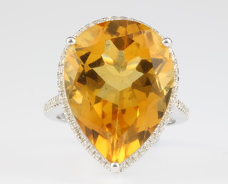 A 14ct gold topaz and diamond ring, the centre pear shaped stone surrounded by brilliant cut diamonds, size M 
