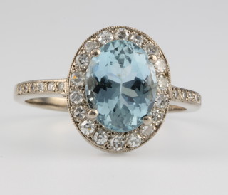 An 18ct white gold aquamarine and diamond cluster ring, the centre stone approx 1ct surrounded by diamonds approx. 0.3ct 