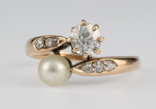 A 14ct gold diamond and pearl cross-over ring, the diamond approx 0.5ct, size M