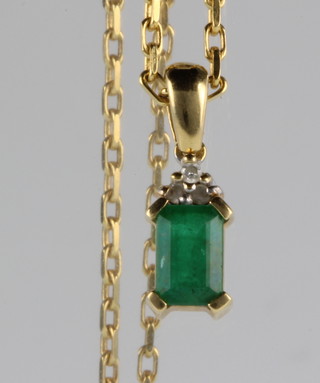 An 18ct yellow gold diamond and emerald pendant on a ditto chain 