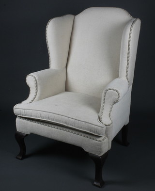 A winged arm chair upholstered in white material, raised on cabriole supports 