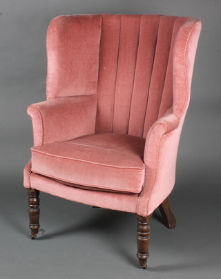 A Georgian tub back library chair upholstered in pink dralon, raised on turned supports 