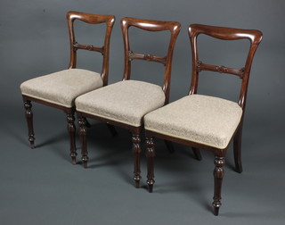 A set of 3 Victorian mahogany buckle back dining chairs with carved mid rails and upholstered seats, on turned and reeded supports 