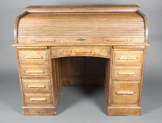 An oak kneehole roll top desk with fitted interior, the pedestals fitted brushing slides and 6 drawers 39"h x 48"w x 28"d 