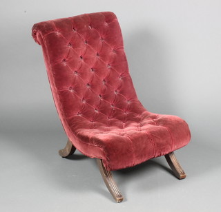 A Victorian nursing chair upholstered in red buttoned back material, on scroll supports 