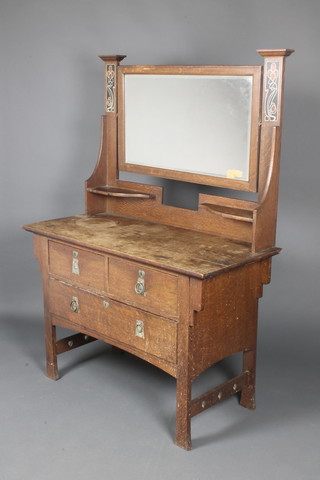 A Liberty's style Art Nouveau inlaid oak 2 piece bedroom suite comprising wardrobe with moulded cornice fitted 2 hanging cupboards enclosed by bevelled plate mirrored doors, the centre section with recess above cupboard and 3 long drawers, the base fitted 1 long and 1 short drawer 80"h x 72"w and a dressing table with rectangular plate mirror, fitted 2 short drawers above 1 long drawer, 64"h x 45"w x 21"d 