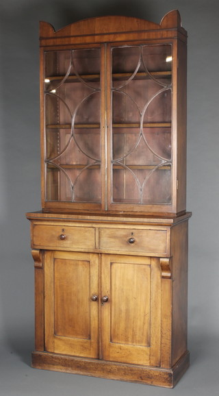 A Victorian mahogany bookcase on cabinet, the upper section with moulded cornice by astragal glazed panelled doors, the base fitted 2 drawers above double cupboards, raised on a platform base 87 1/2"h x 37"w x 18"d 