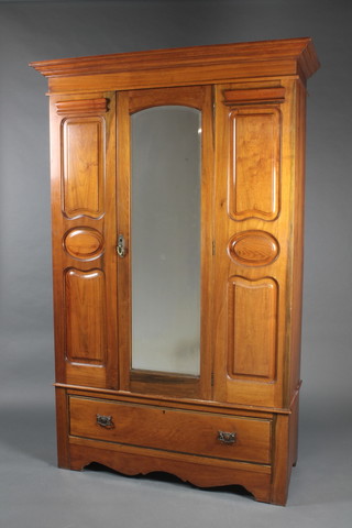 An Art Nouveau walnut wardrobe with moulded cornice and arched bevelled plate mirrored door, the base fitted a drawer 80"h x 51"w x 20 1/2"d  