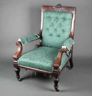 A Victorian mahogany show frame armchair with carved back, upholstered in green material, raised on turned supports 