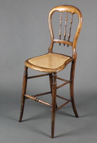 A Victorian mahogany stick back childs training chair with woven cane seat, raised on turned supports