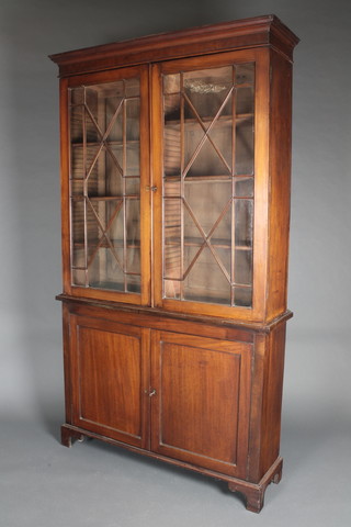 A 19th Century mahogany bookcase on cabinet, the upper section with moulded cornice, fitted adjustable shelves enclosed by astragal glazed doors, the base fitted a cupboard enclosed by panelled doors, raised on bracket feet 81 1/2"h x 46 1/2"w x 13 1/2"d 