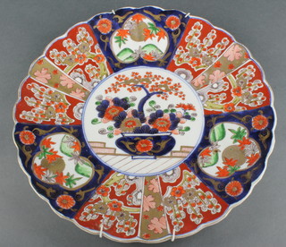 A 19th Century Imari scalloped dish with a vase of flowers enclosed by panels of landscapes and flowering peony 13" 