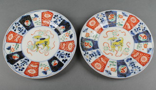 A pair of 19th Century Imari plates with a figure of a yellow dog enclosed in a border of flowers, insects and birds 8" 