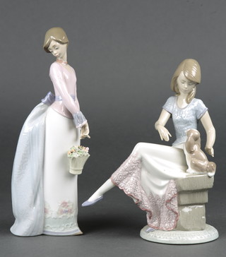 A Lladro figure of a seated girl and puppy 7612, 8 1/2", a ditto of a standing lady with basket of flowers 10" 