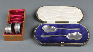 A pair of cased silver serving spoons, Sheffield 1918 36 grams and a cased pair of silver napkin rings, Chester 1909, 14 grams