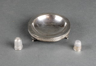 A circular silver dish with pierced border and 2 ditto thimbles 62 grams
