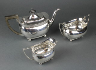 A silver 3 piece tea set of oblong form with ebony mounts, on ball feet, Chester 1911/1912, gross 1068 grams
