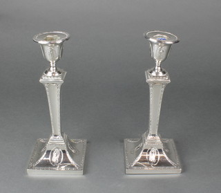 A pair of Edwardian silver Adam style candlesticks with tapered stems, decorated with panels of classical figures, Sheffield 1905, 8 1/2" 