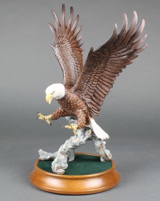 A Franklin Mint figure of an eagle on a branch with outstretched wings on a wooden base 14" 