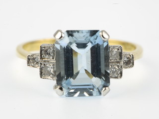 An 18ct gold aquamarine and diamond ring, the rectangular cut aquamarine approx. 0.3ct supported by 3 diamonds to each shoulder approx 0.2ct, size N 1/2