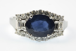 A sapphire and diamond white gold ring, the oval cut centre stone approx 3.6ct, surrounded by 0.85ct of diamonds, size P 1/2 