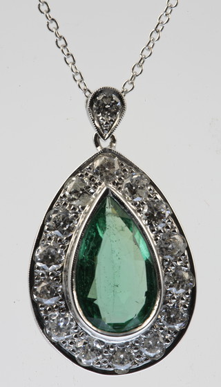 A white gold emerald and diamond pear shaped pendant, the centre stone approx. 3ct surrounded by 14 brilliant cut diamonds suspended by a brilliant cut diamond on an 18ct white gold chain 