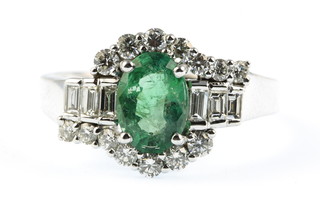 A 14ct white gold emerald and diamond Art Deco style ring, the centre stone approx. 1.3ct, surrounded by brilliant and baguette cut diamonds approx. 0.9ct, size P