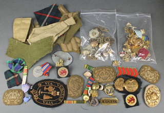 A quantity of First World War cap badges, cloth badges and minor medals
